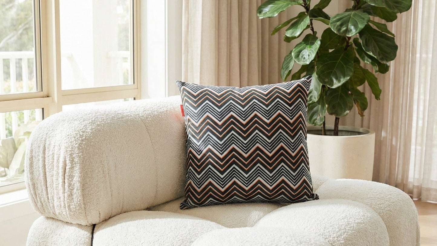 Decorative cushion in orange, black and white on chunky white couch