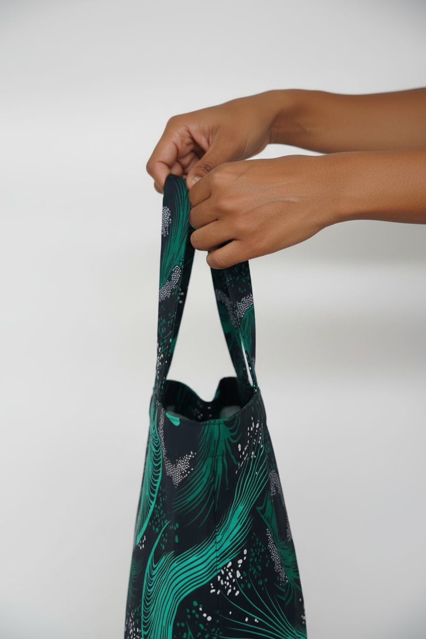 Hands holding Emerald Swell tote showing scale and comfortable grip