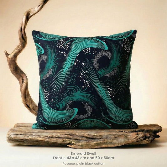 Decorative cushion with green and black abstract design on driftwood with neutral background