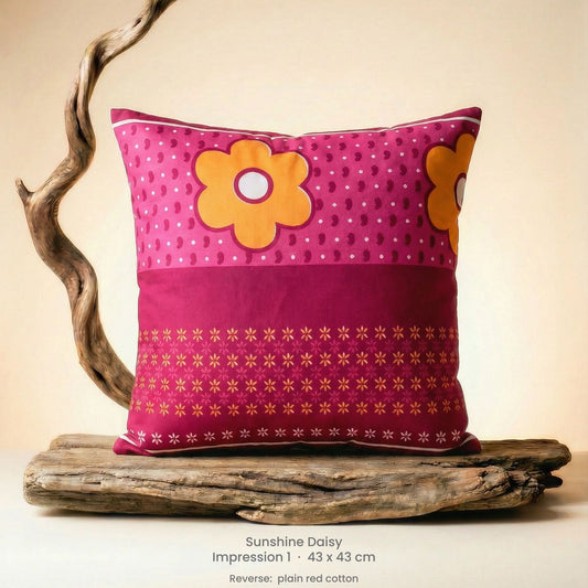 Decorative cushion with floral design in pink, red and yellow on driftwood.