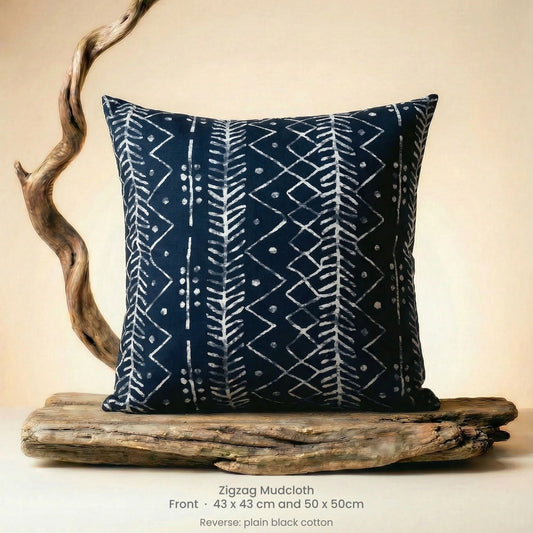 Black and white zigzag patterned pillow on driftwood with a beige background