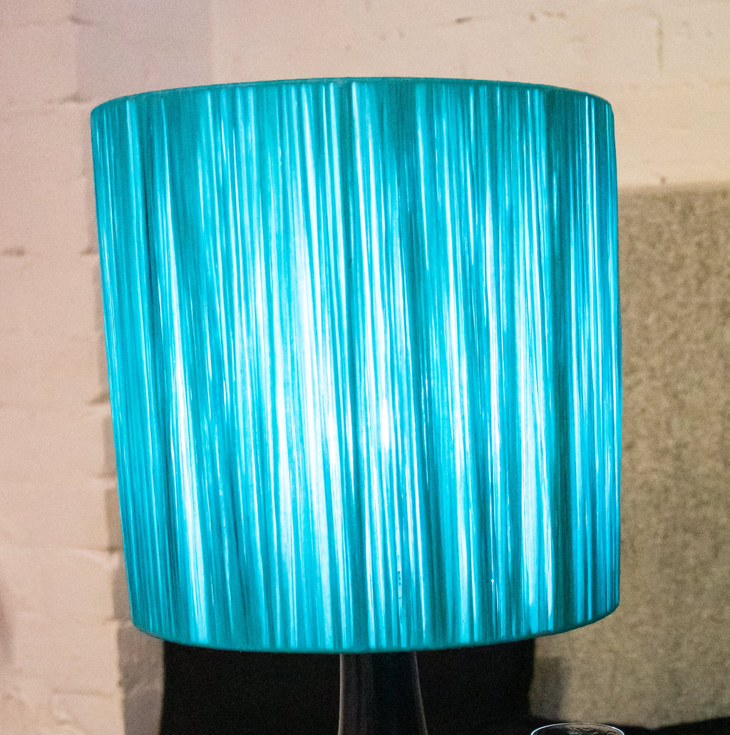 Close up of a turquoise raffia wrapped lampshade.