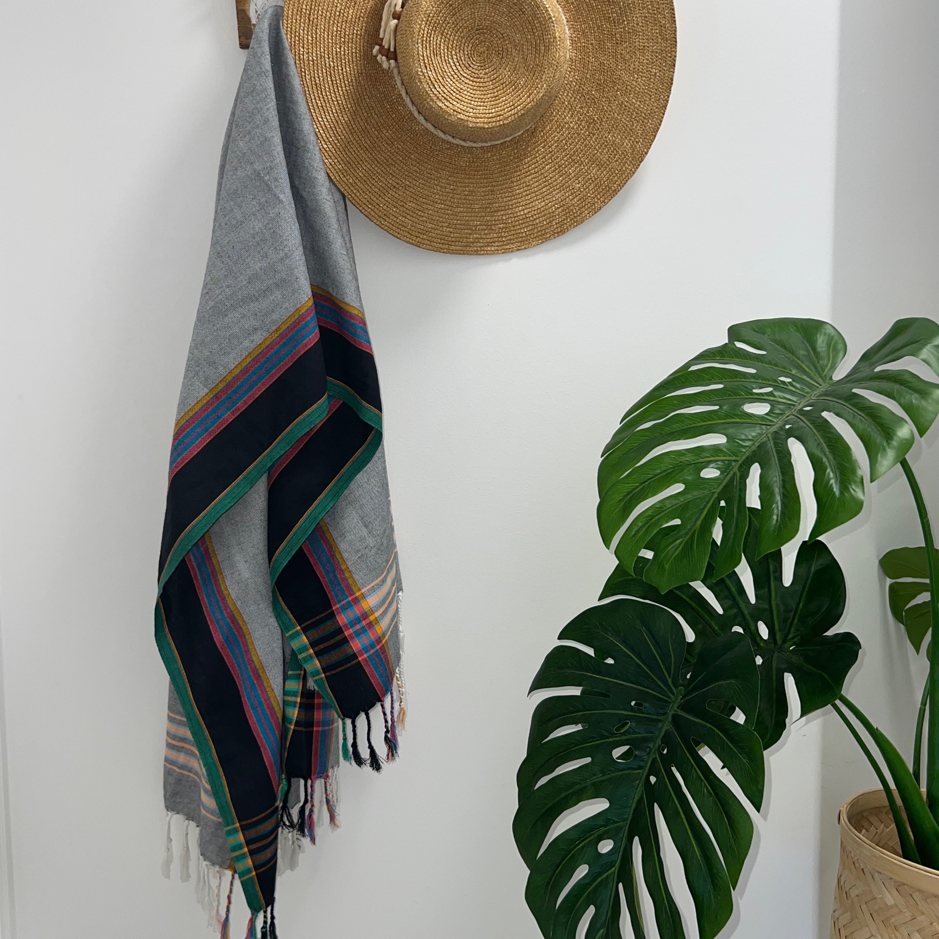 Black Grey & Green Throw Rug on wall hook with straw hat