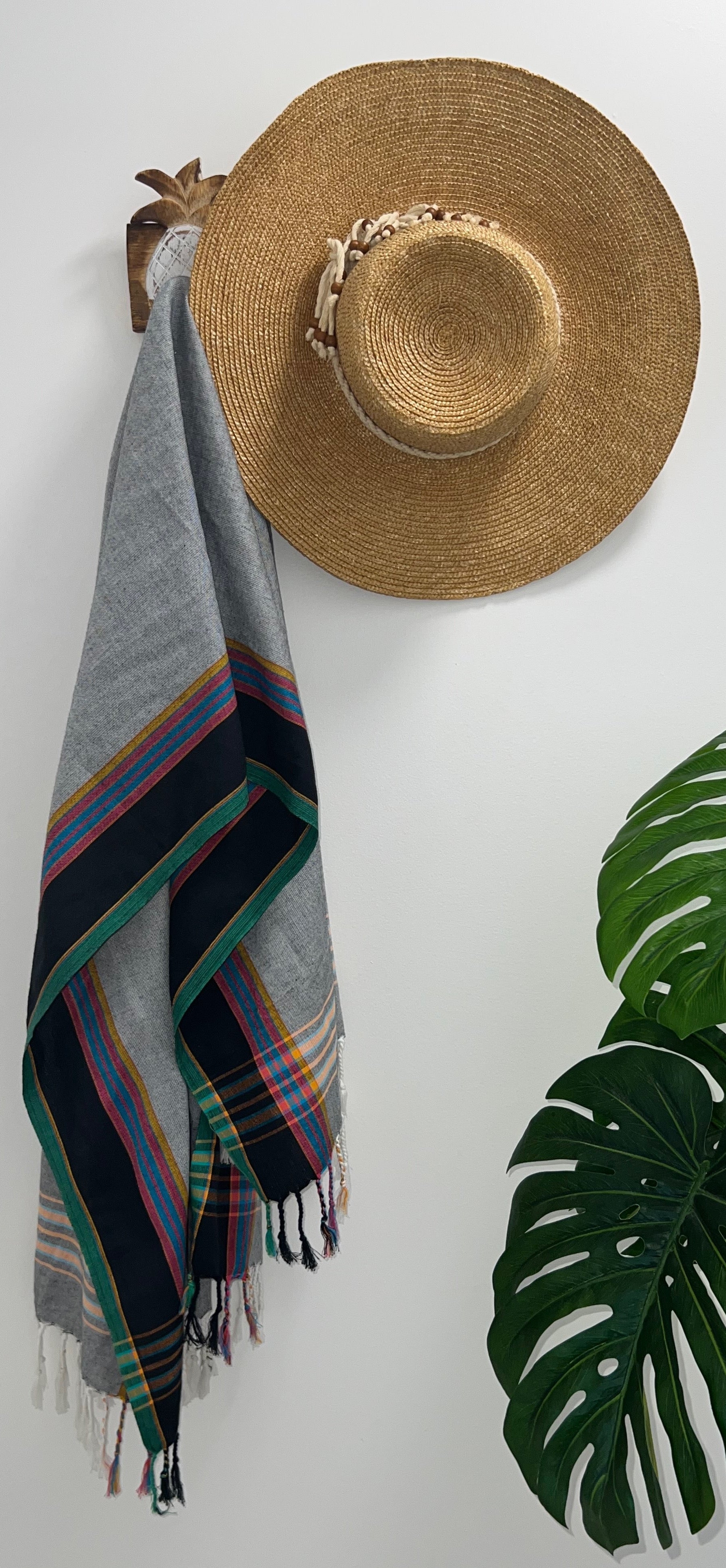 Black Grey & Green Throw Rug on wall hook with straw hat