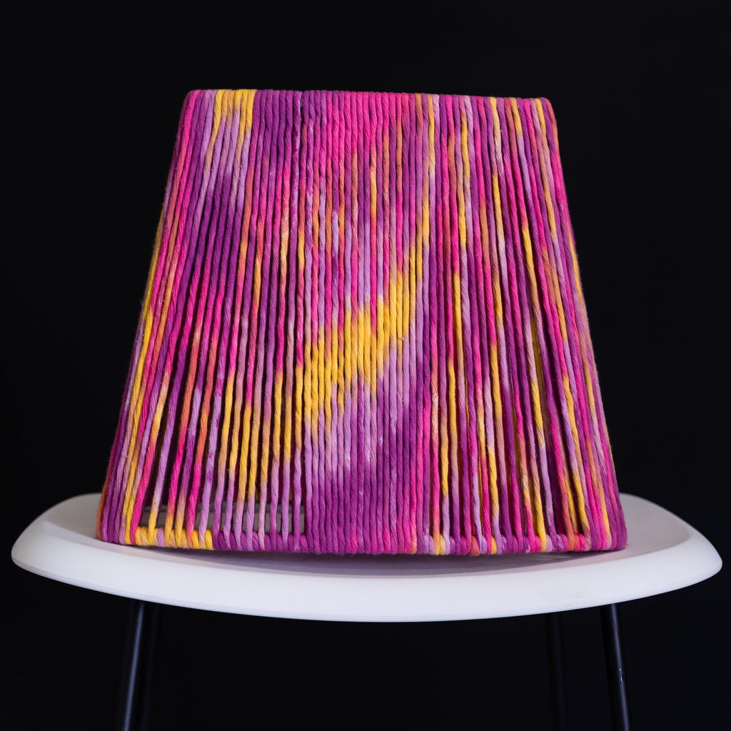 Colorful lampshade with pink and yellow patterns on a black background
