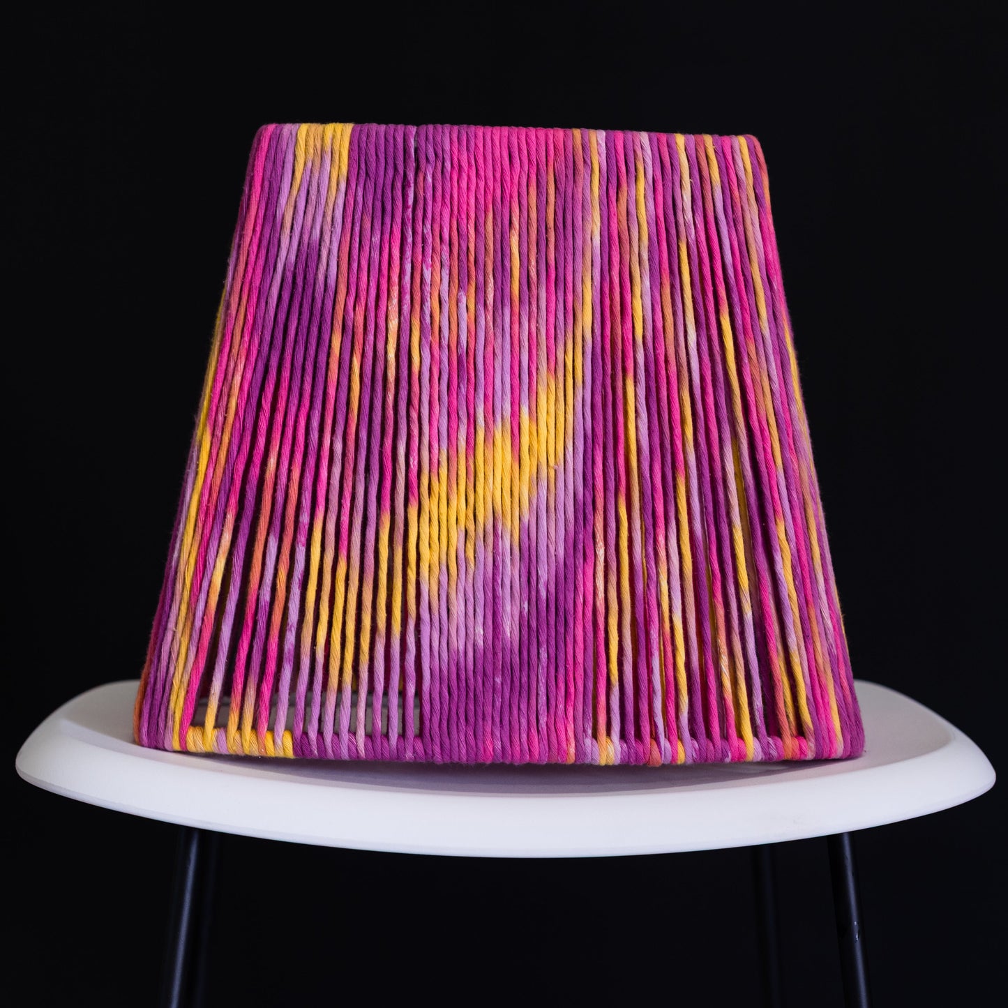 Colorful lampshade with pink and yellow patterns on a black background