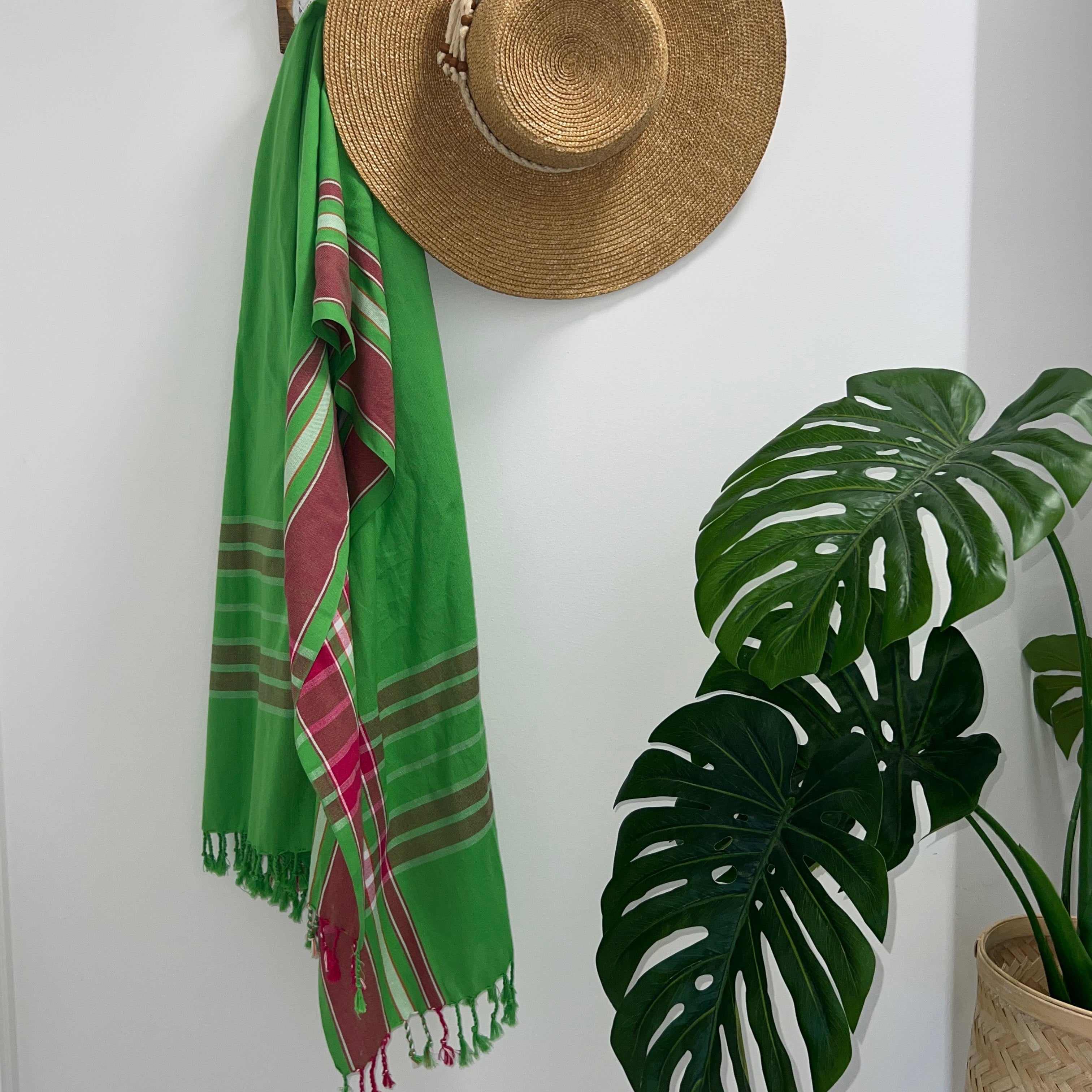 Green Pink & White Throw Rug on wall hook with straw hat