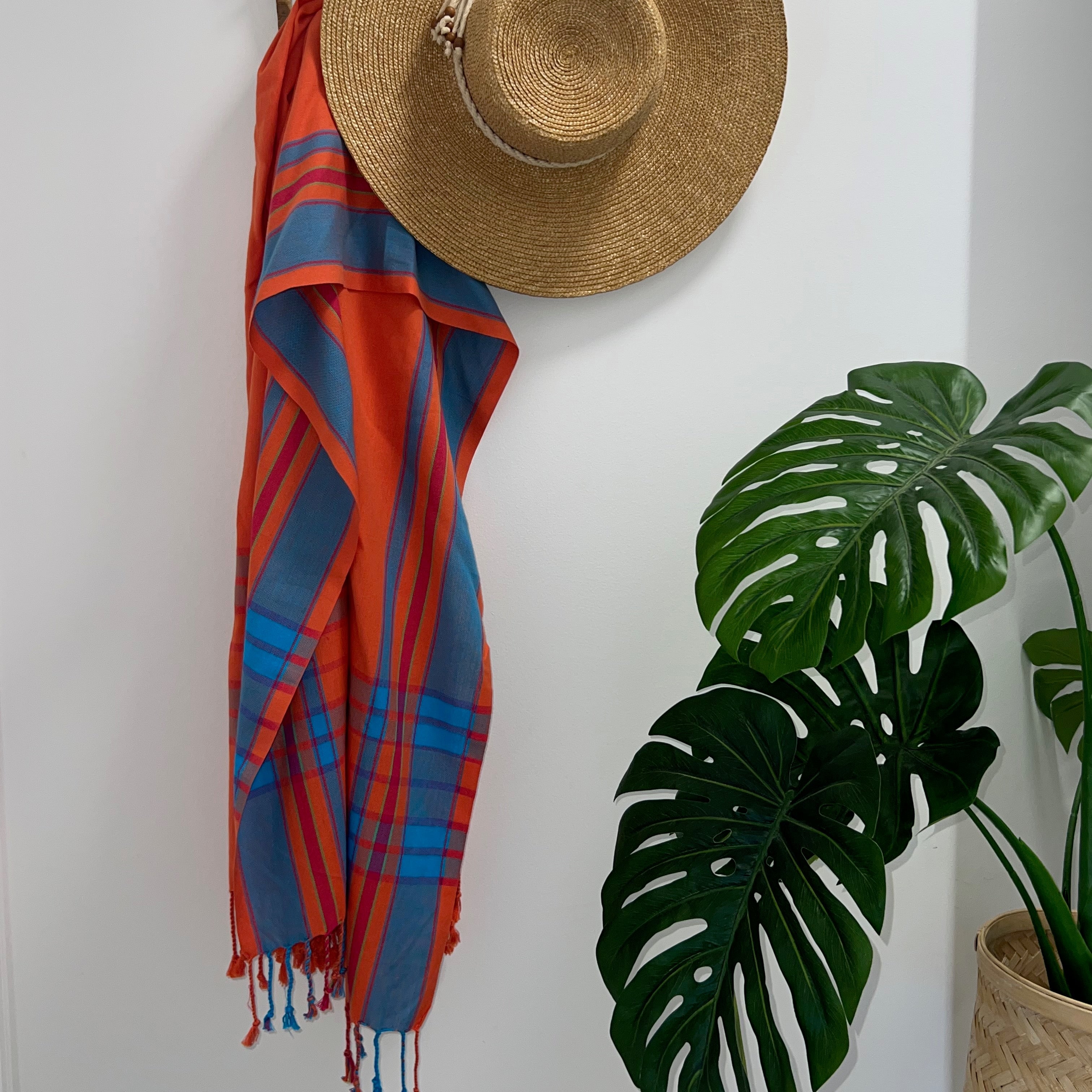 Orange & Turquoise Throw Rug on wall hook with straw hat