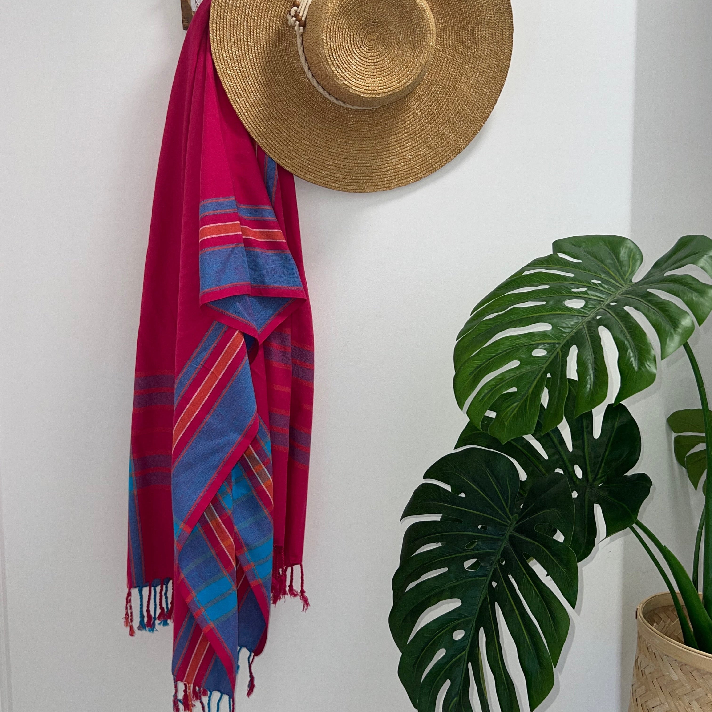 Red Turquoise & Orange Throw Rug on wall hook with straw hat