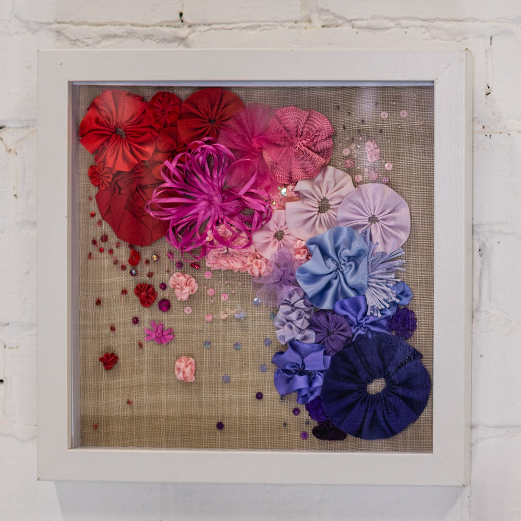 Framed artwork with colourful ribbon flowers on a textured background