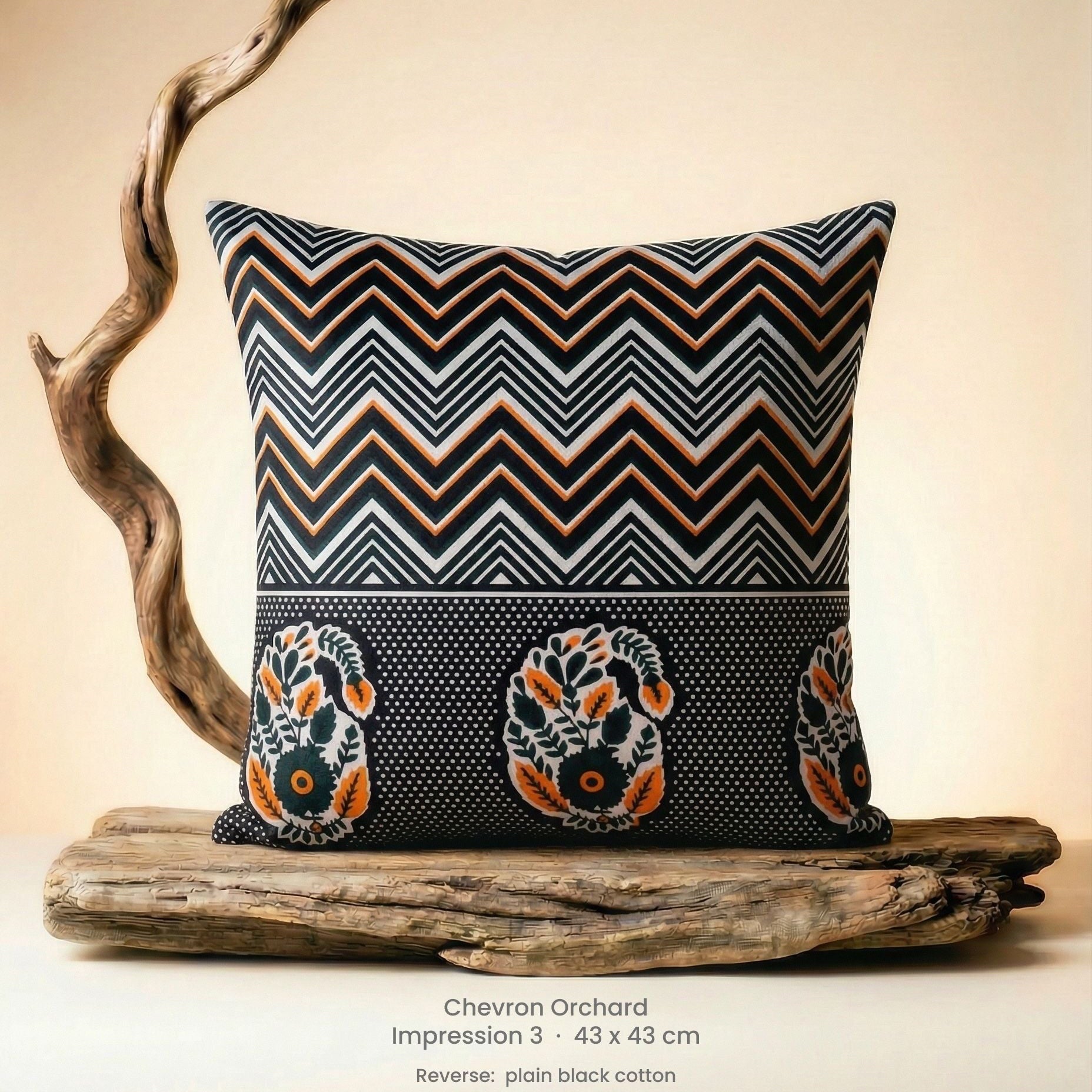 Decorative cushion in orange, black and white on driftwood.