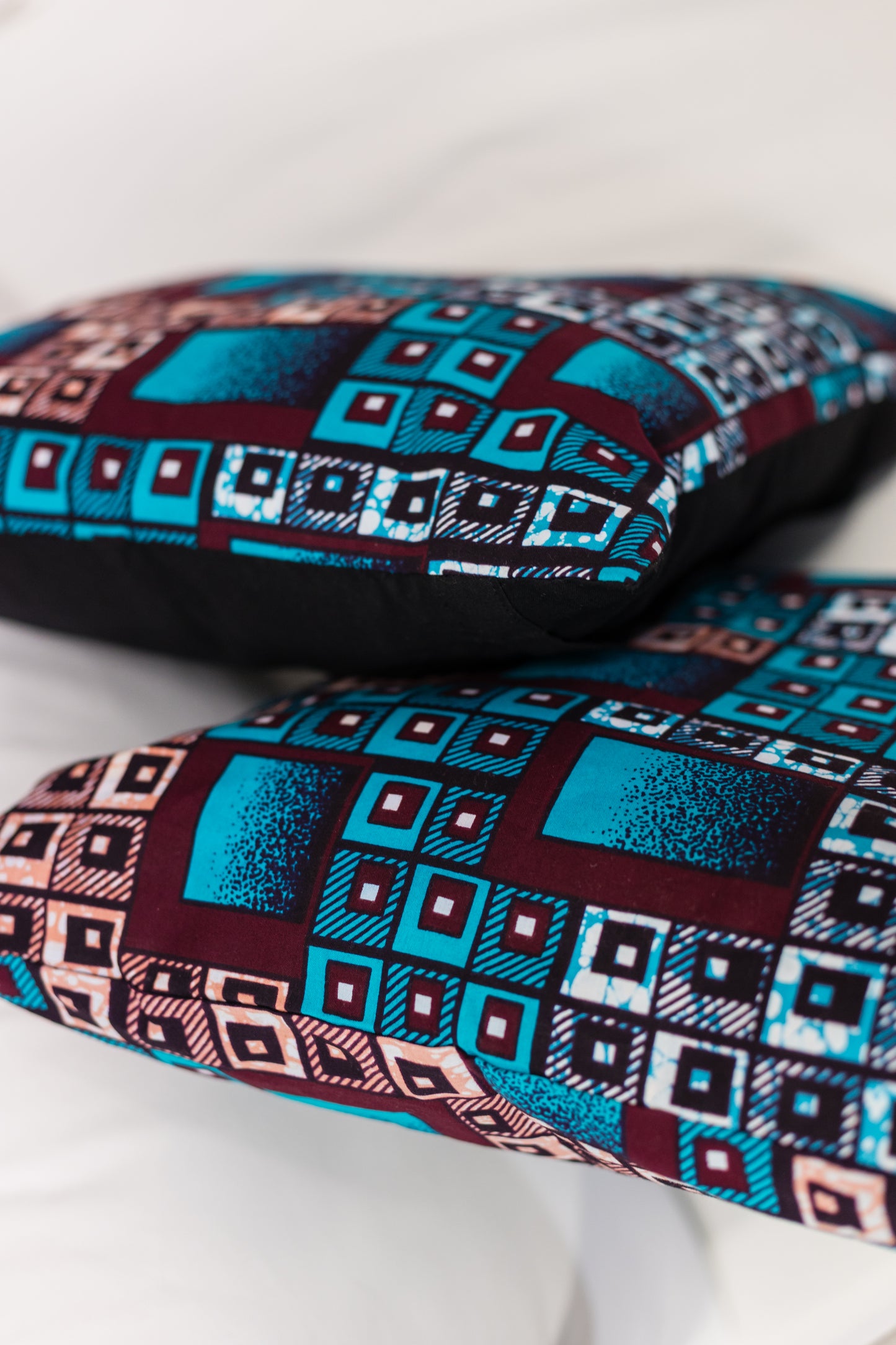 Two African batik print cushions on a white background