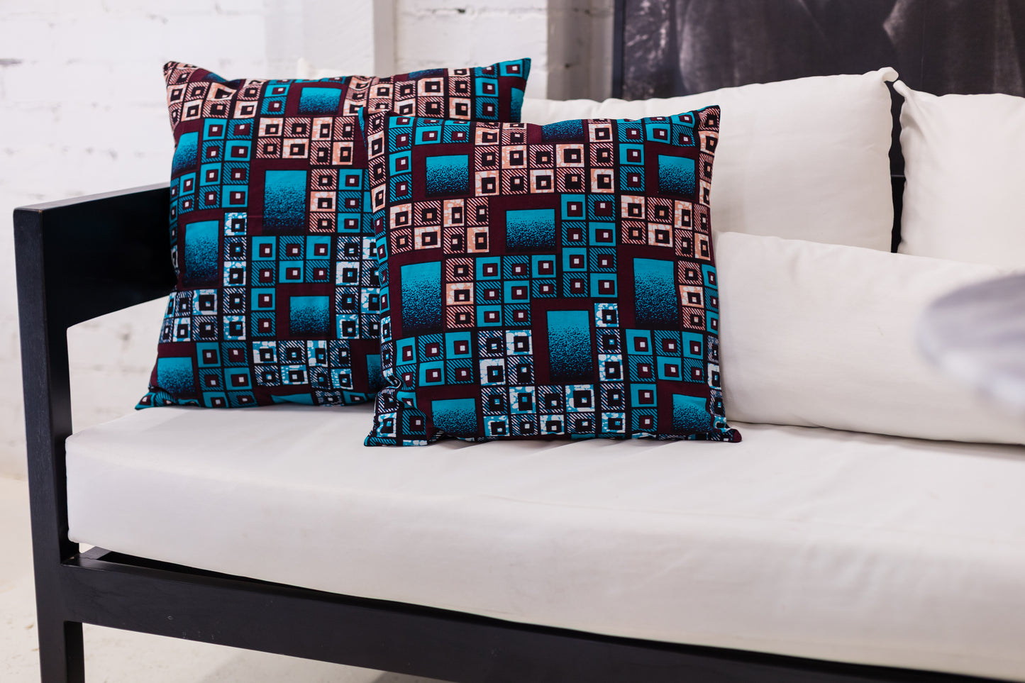 Patterned cushions on a white sofa with a white wall background