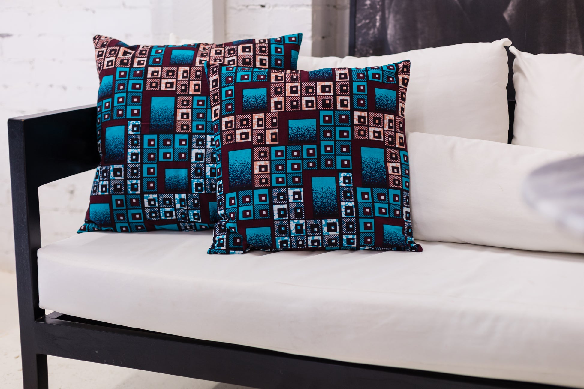 Patterned cushions on a white sofa with a white wall background