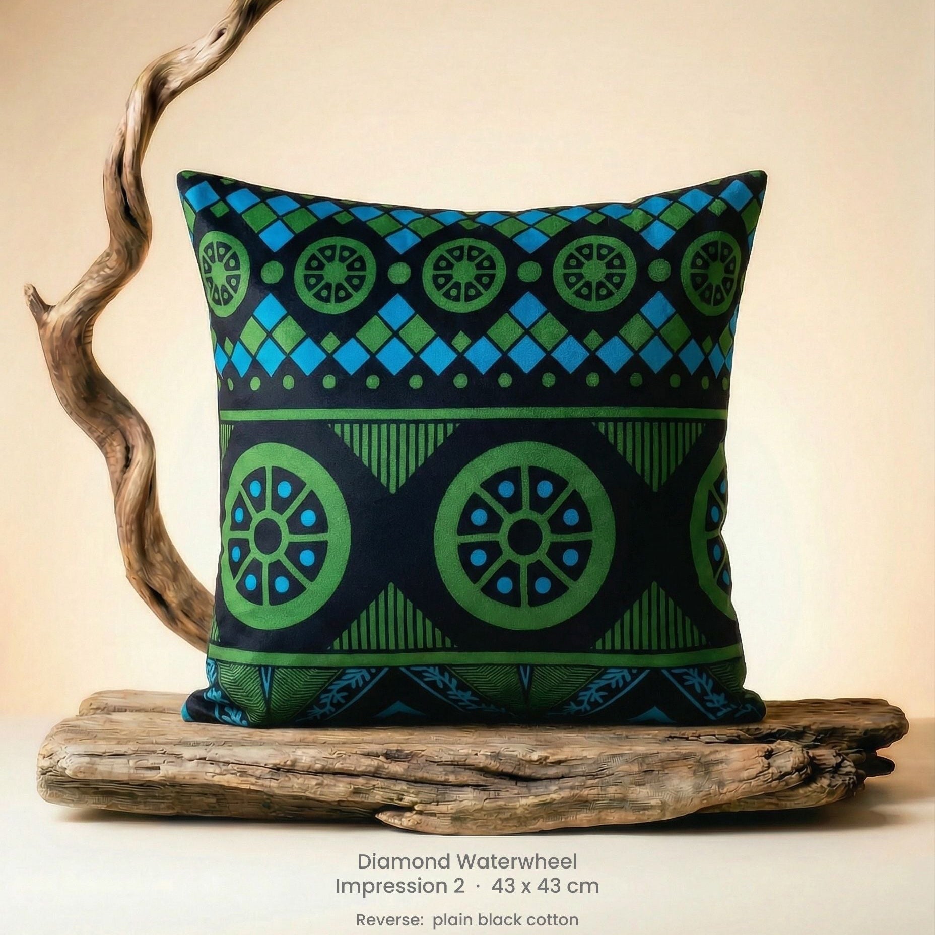 Decorative green, blue and black cushion with geometric pattern on driftwood with a neutral background.