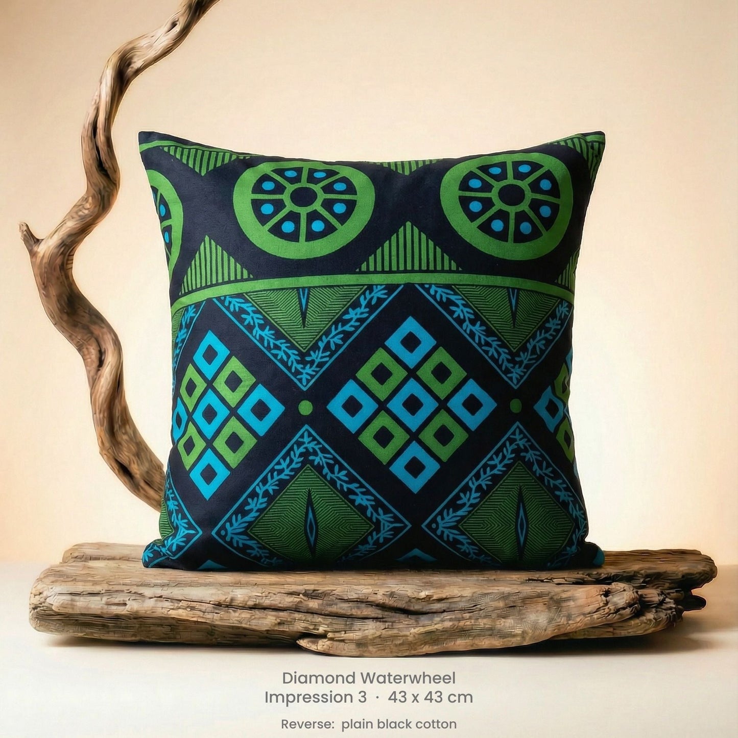 Decorative green, blue and black cushion with geometric pattern on driftwood with a neutral background.