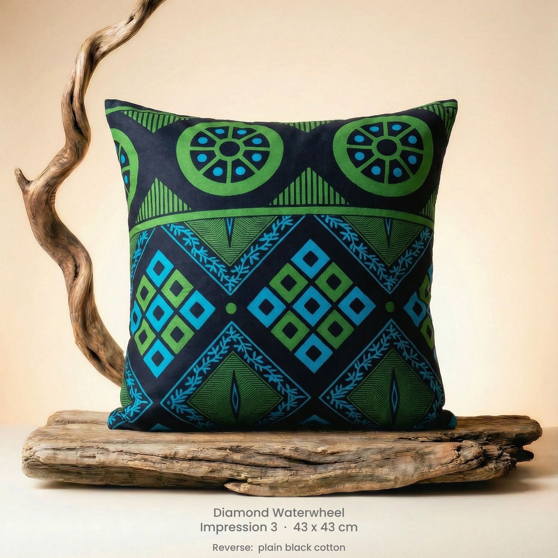 Decorative green, blue and black cushion with geometric pattern on driftwood with a neutral background.