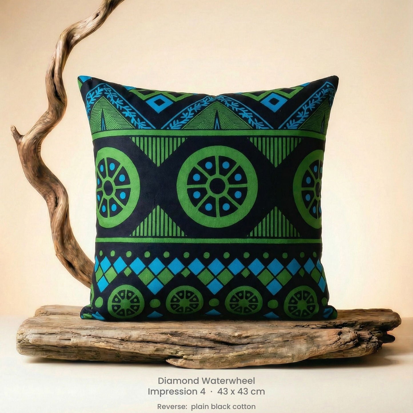 Decorative green, blue and black cushion with geometric pattern on driftwood with a neutral background.