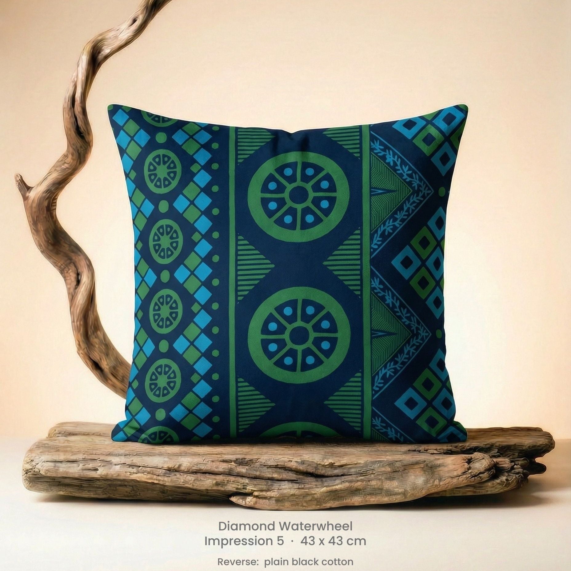 Decorative green, blue and black cushion with geometric pattern on driftwood with a neutral background.