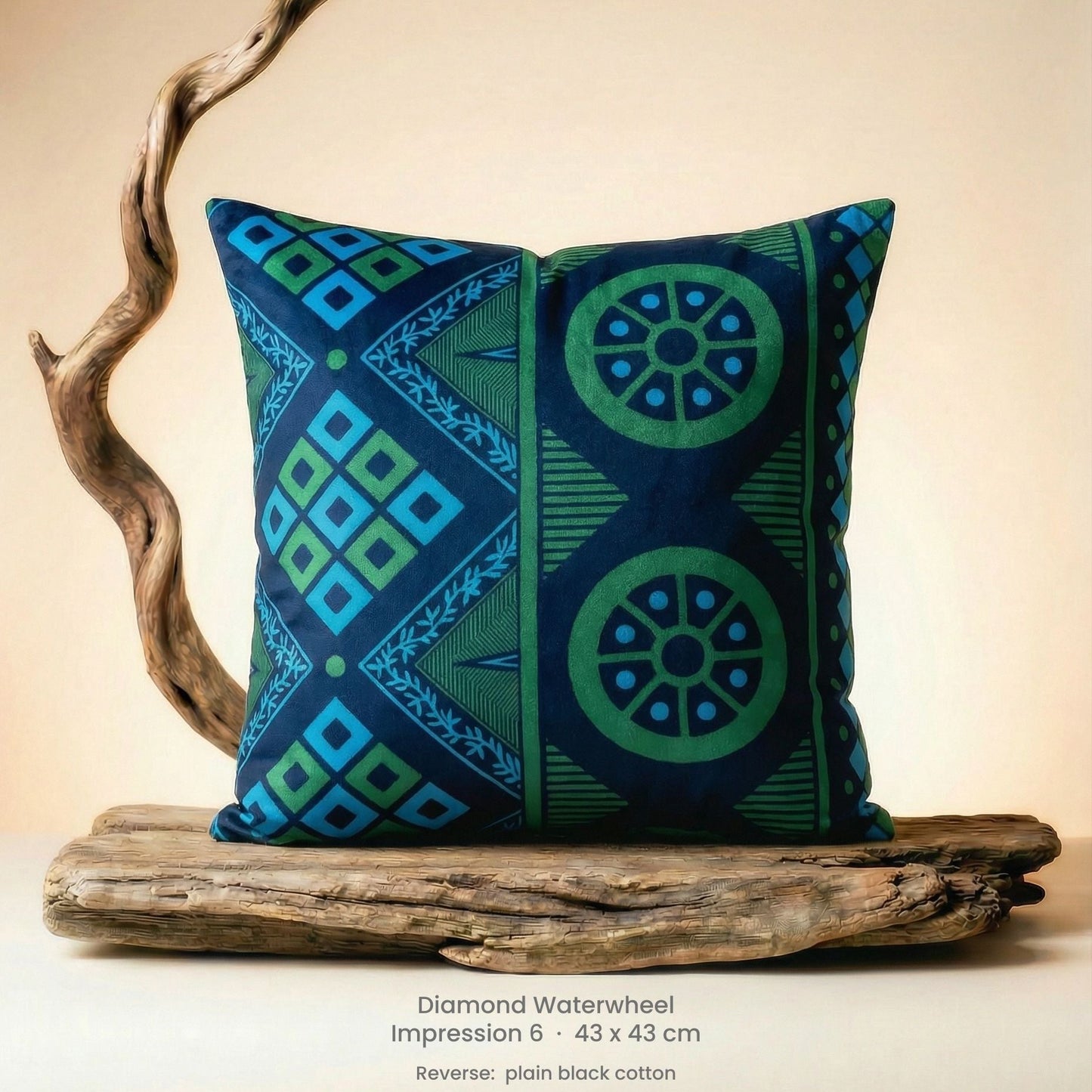 Decorative green, blue and black cushion with geometric pattern on driftwood with a neutral background.