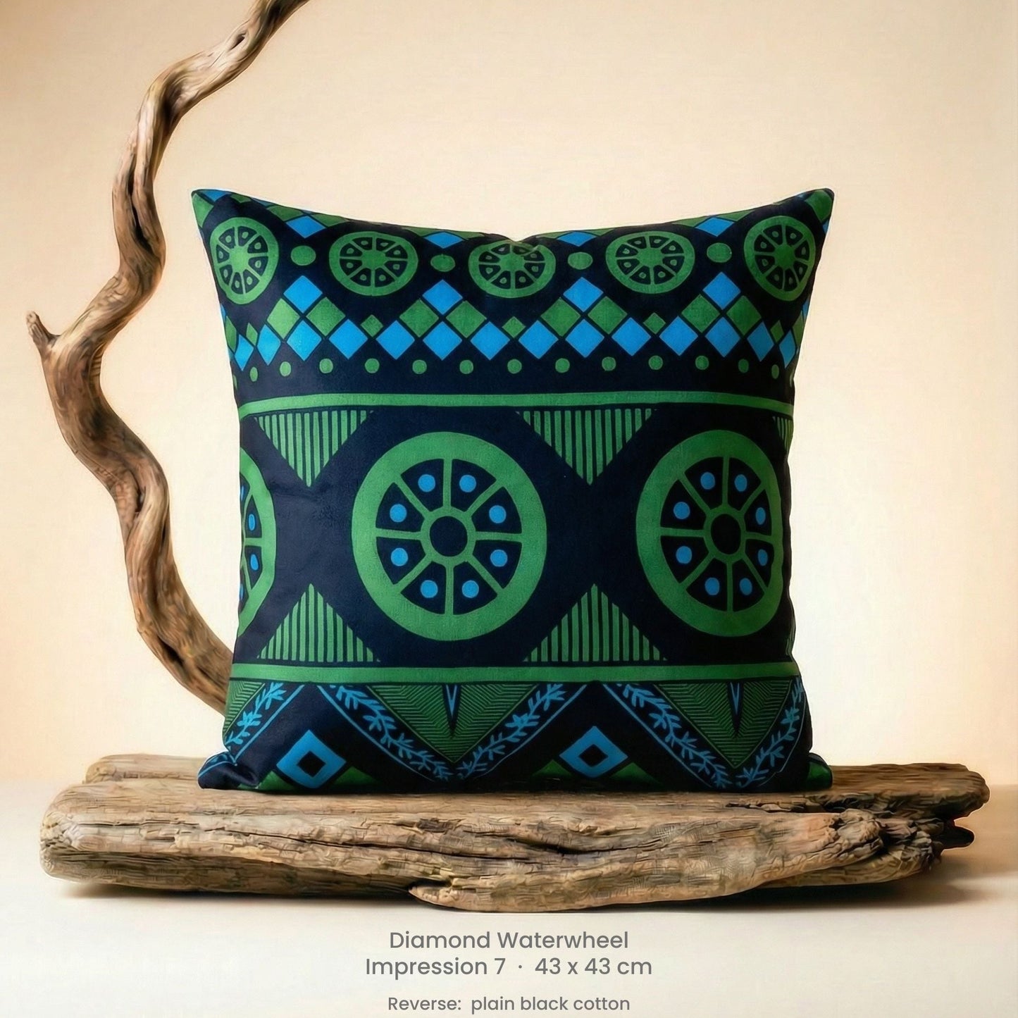 Decorative green, blue and black cushion with geometric pattern on driftwood with a neutral background.
