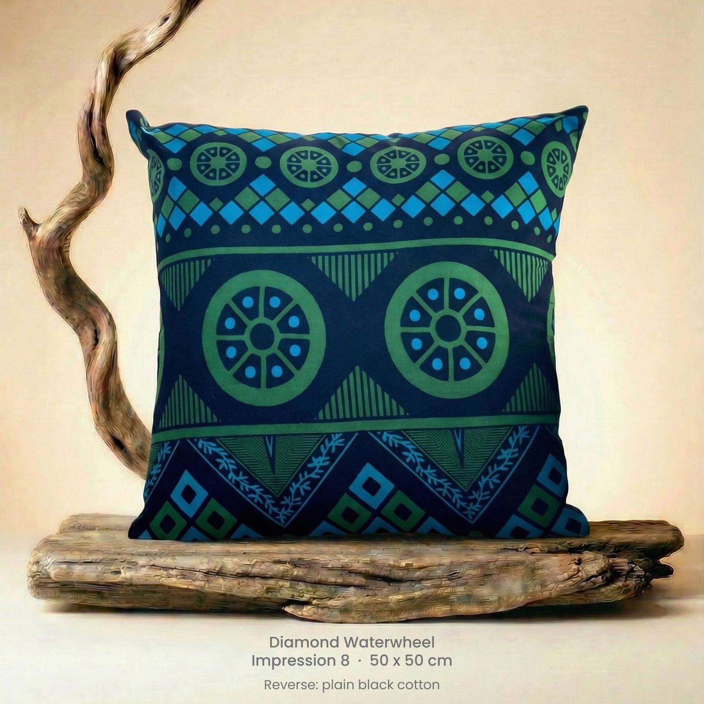 Decorative green, blue and black cushion with geometric pattern on driftwood with a neutral background.