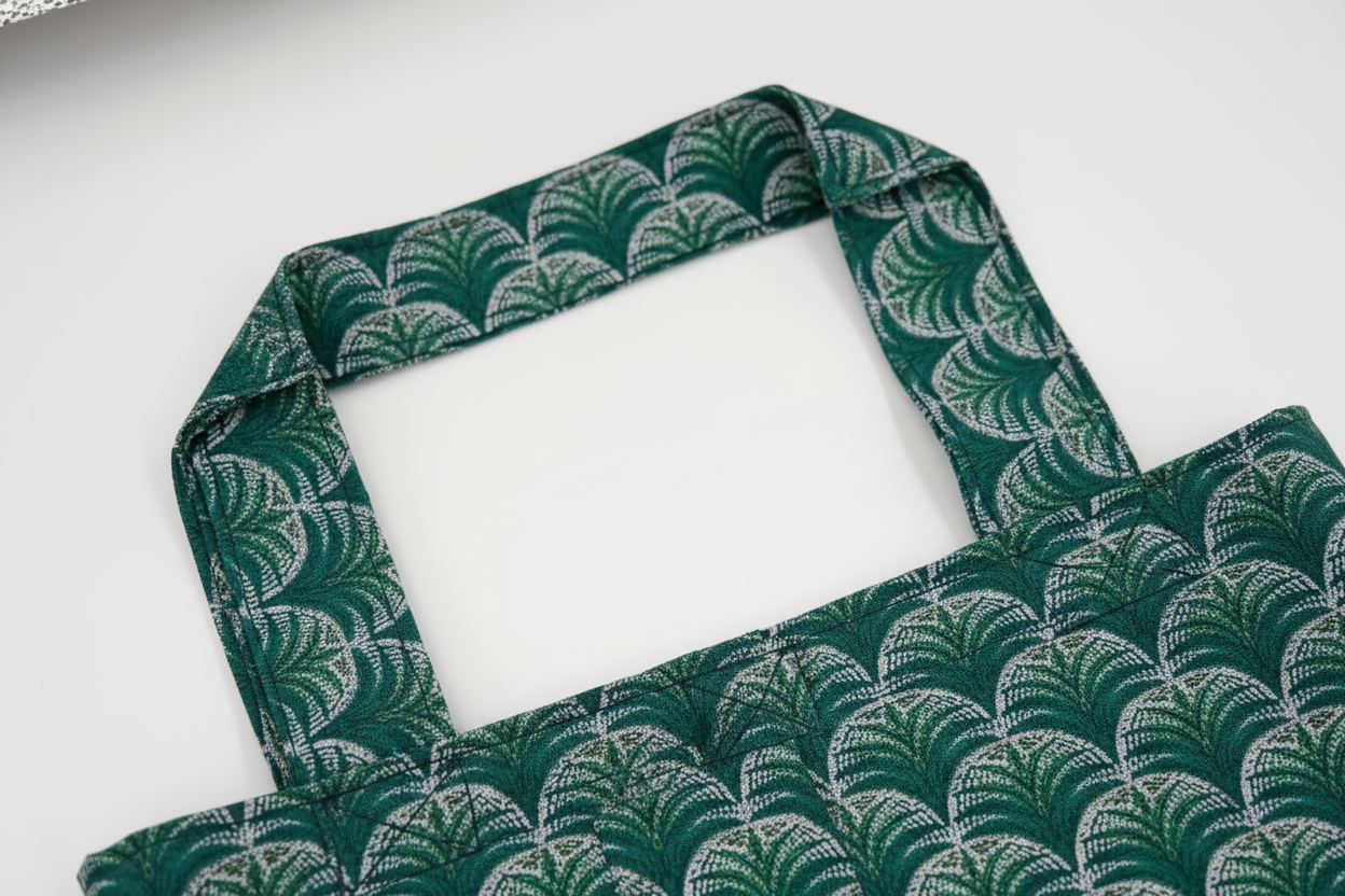 Close-up of handle construction and stitching detail on Fountain Palm tote showing quality craftsmanship
