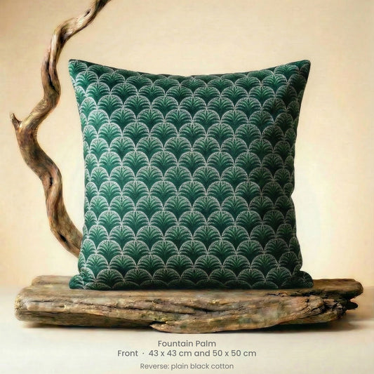 Decorative cushion in green, black and white on driftwood.
