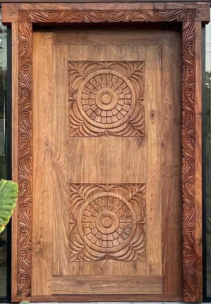 Wooden door with intricate carvings in front of a modern building with glass windows and stone walls.