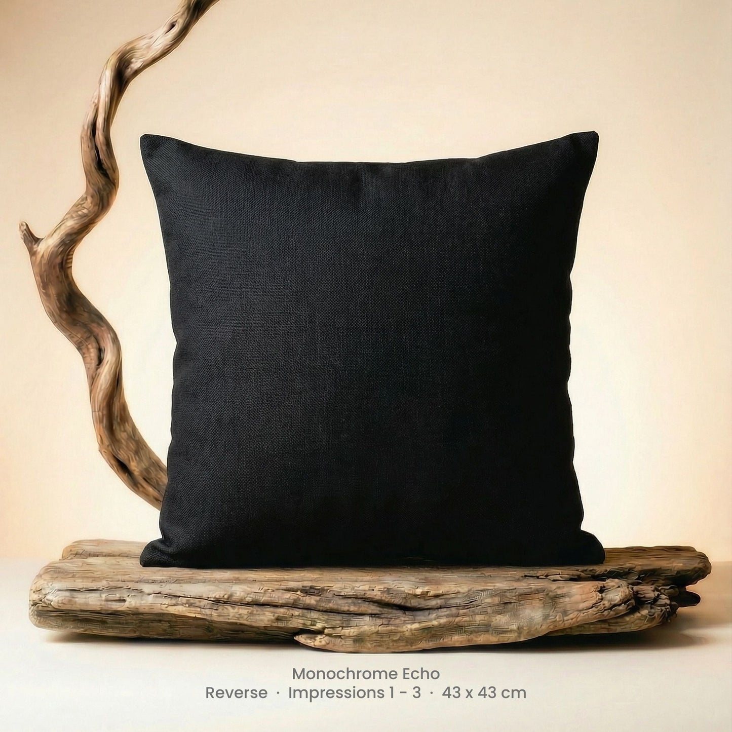 Black pillow on driftwood with a neutral background