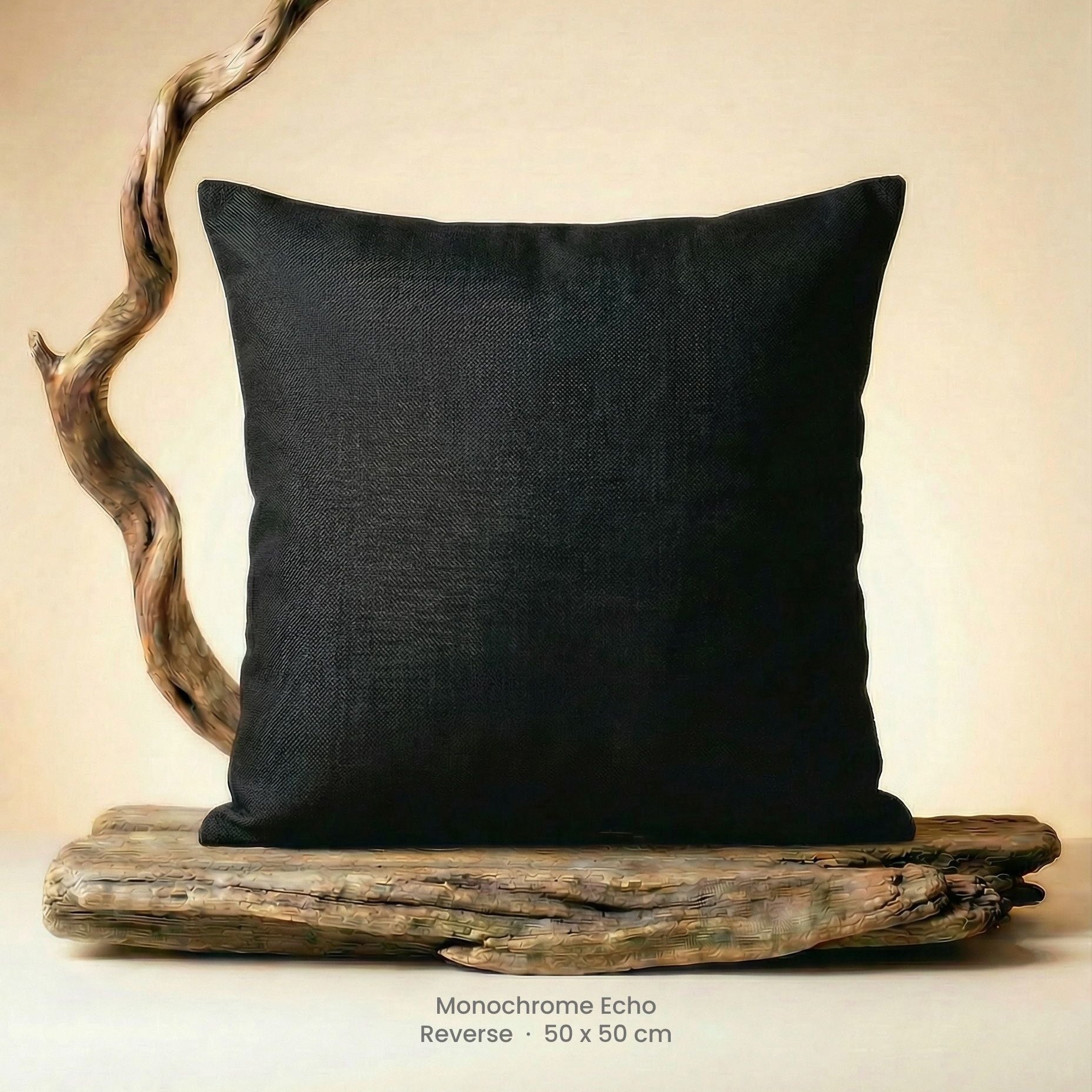 Black pillow on driftwood with a neutral background