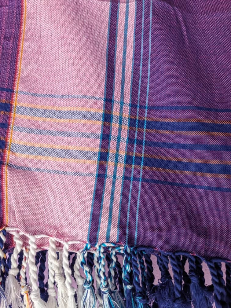 Closeup of a purple, pink and blue plaid fabric with tassels
