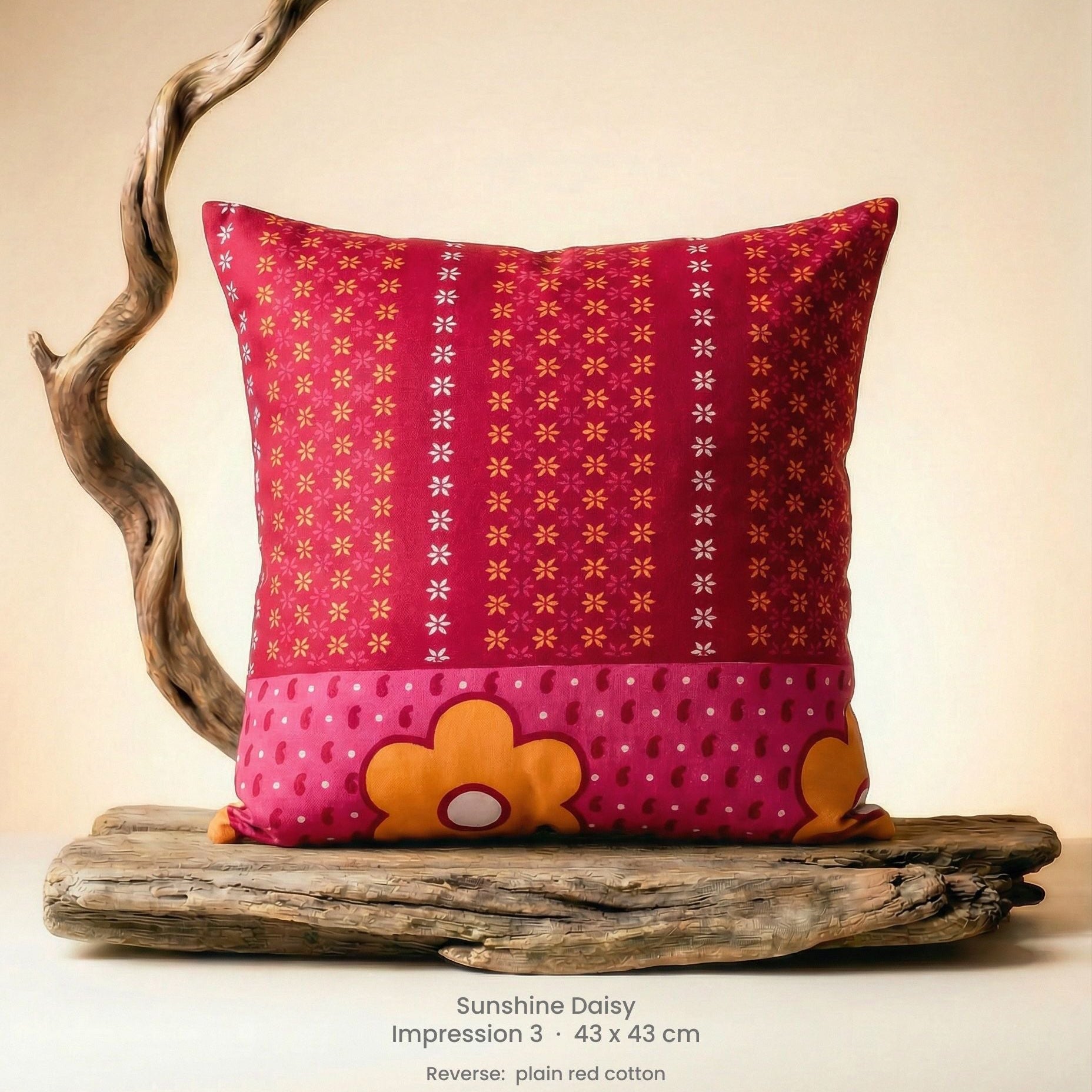 Decorative cushion with floral design in pink, red and yellow on driftwood.