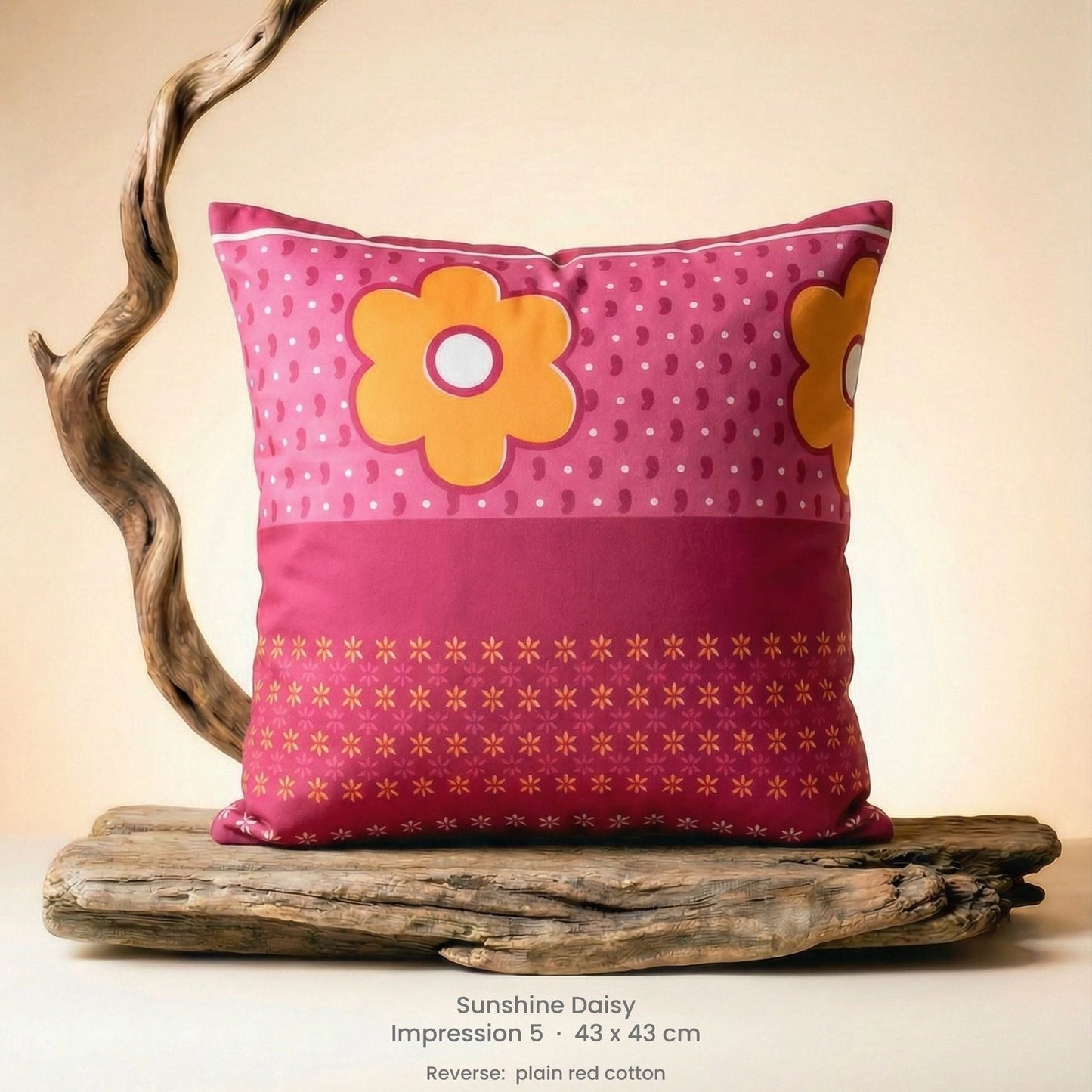 Decorative cushion with floral design in pink, red and yellow on driftwood.