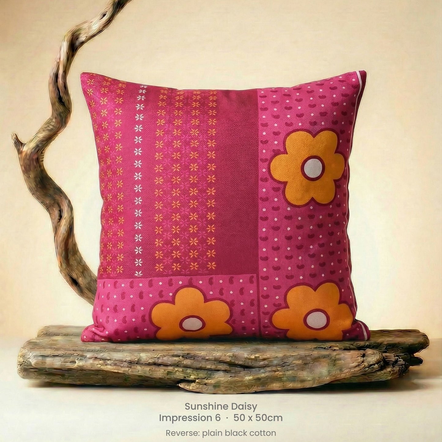 Decorative cushion with floral design in pink, red and yellow on driftwood.