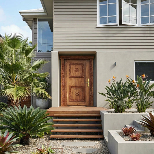 Exterior of postwar house renovation with Zanzibar Door surrounded by tropical garden